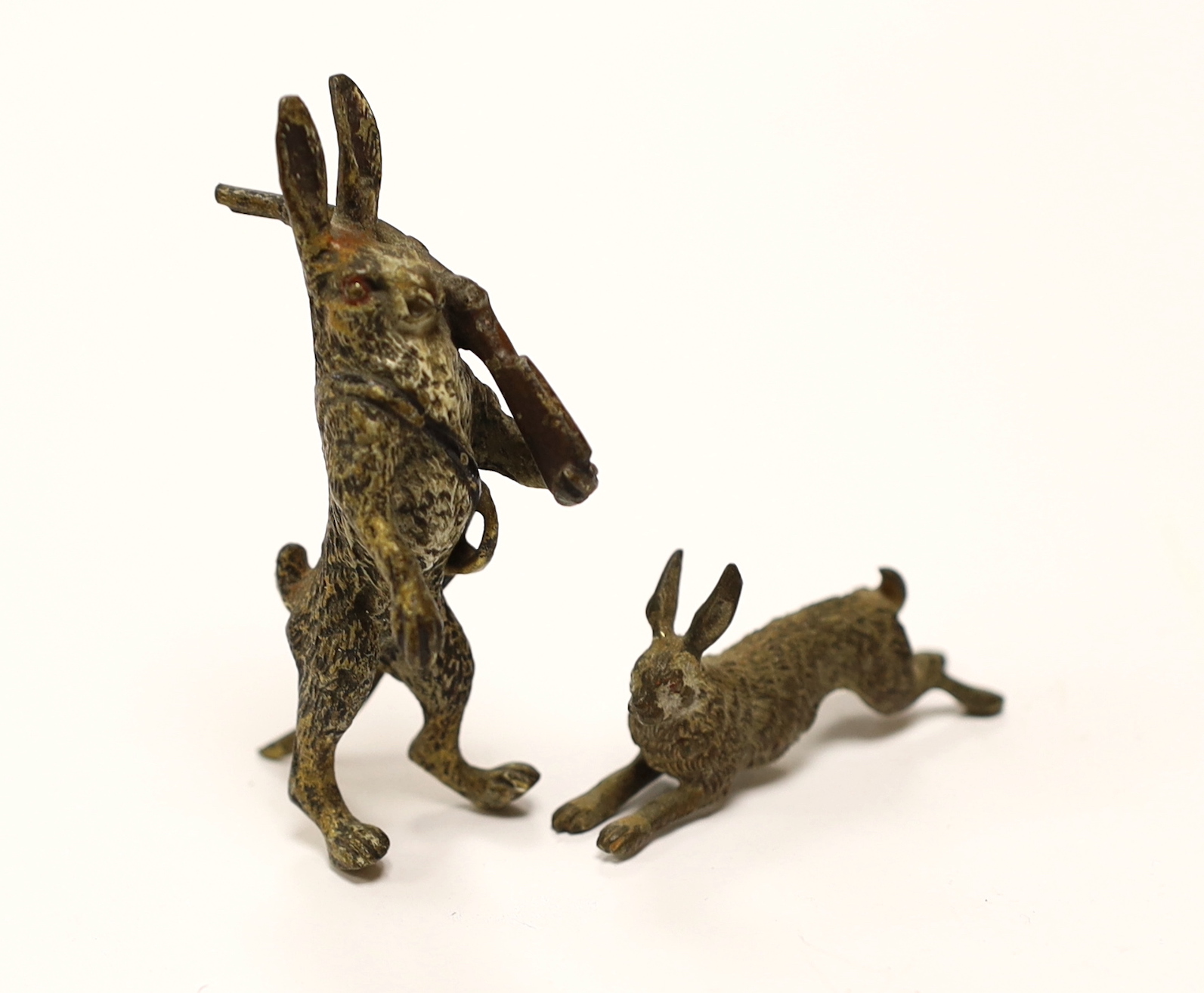 A novelty Austrian cold painted bronze model of a Hare with a rifle slung over its shoulder, 6.5cm, together with a similar smaller rabbit